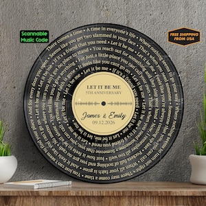 May include: A circular black wall art piece designed like a vinyl record featuring lyrics to the song Let It Be Me spiraling around the center. The gold center label displays the text Let It Be Me, 5th Anniversary, James & Emily, 09.12.2026.