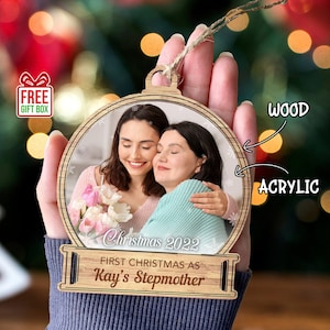 May include: A personalized Christmas ornament with a photo of two women. The ornament is made of wood and acrylic. The text on the ornament reads "Christmas 2022 First Christmas as Kay's Stepmother".