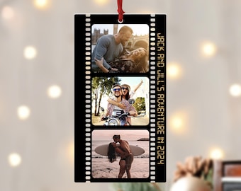May include: A black and white photo strip ornament with three photos of a couple. The photos show the couple in different locations, including a city street, a park, and a beach. The text "Jack and Jill's Adventure in 2024" is printed on the ornament.