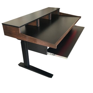 Puede incluir: Un escritorio de pie negro y marrón con una bandeja extraíble para el teclado. El escritorio tiene una superficie superior negra y una base de madera marrón. El escritorio tiene un marco de metal negro y una base de metal negro.