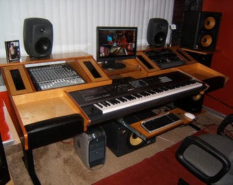 May include: A wooden music production desk with a keyboard, mixer, computer, and speakers. The desk has a light wood finish and black accents.