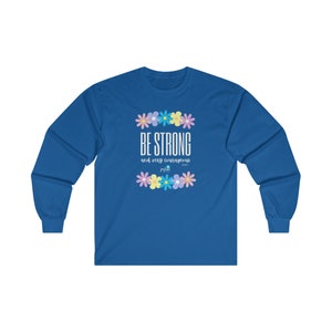 May include: A royal blue long-sleeved t-shirt with a white graphic design featuring a row of colourful flowers and the text "BE STRONG and very courageous".