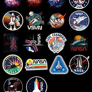 May include: A selection of NASA-themed stickers with diverse designs. The stickers display the NASA logo, space shuttles, planets, and the American flag. The stickers are in various shapes, including circles and triangles.