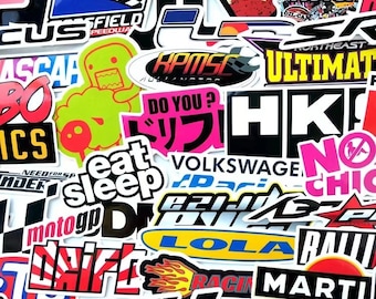 May include: A collection of colorful stickers with various designs and text. The stickers feature racing-themed graphics, Japanese text, and phrases like "Eat Sleep Drift" and "Do You?". The stickers are a mix of shapes and sizes.