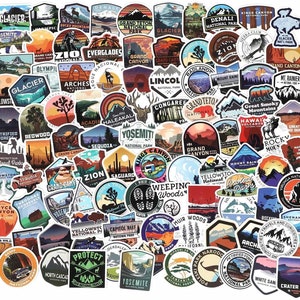 May include: A collection of colorful, die-cut vinyl stickers featuring national park and outdoor adventure themes. Designs include mountain ranges, wildlife, and park names like Yosemite and Glacier National Park.