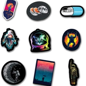 May include: A selection of vibrant stickers with space-themed illustrations. Designs include an astronaut on a planet, a cat in a space helmet, and a pill with an astronaut inside. Each sticker has a white border.
