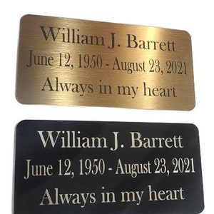 May include: Two gold and black memorial plaques with the text "William J. Barrett June 12, 1950 - August 23, 2021 Always in my heart"