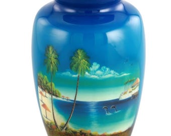 May include: A blue cremation urn with a glossy finish. The urn features a painted tropical beach scene with palm trees, ocean, and dolphins. The lid is a matching blue color.