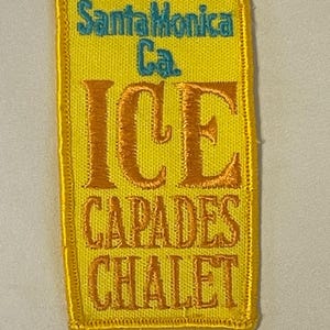 Peut inclure: Écusson brodé jaune avec le texte "Santa Monica Ca. ICE CAPADES CHALET" en orange et turquoise.