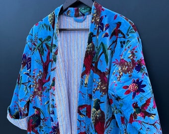 May include: A blue velvet robe with a floral and bird print. The robe has a striped lining and a tie closure.
