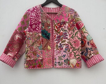 Op de afbeelding: Een roze gewatteerd jack met een bloemig patchwork-ontwerp. Het jack heeft een ritssluiting en lange mouwen.