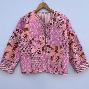 May include: A pink quilted jacket with a floral and tiger print. The jacket has a button closure and long sleeves.