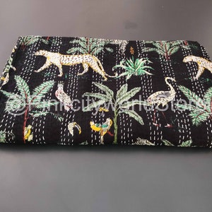 May include: Black kantha quilt with a jungle print featuring leopards, birds, and palm trees.