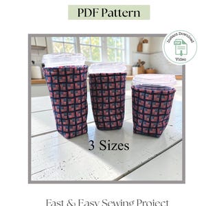 May include: Three fabric ice drink sleeves in three different sizes, each featuring a repeating American flag pattern on a dark blue background. The sleeves are shown wrapped around clear plastic cups with lids. Text reads Ice Drink Sleeve, PDF Pattern, 3 Sizes, Fast & Easy Sewing Project, and Instant Download.
