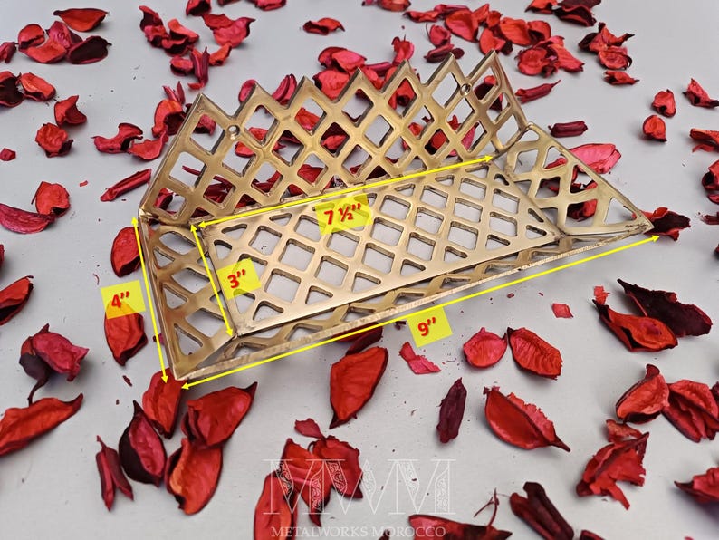 May include: A gold metal decorative tray with a diamond-shaped grid pattern. The tray measures 9 inches long, 7 1/2 inches wide, and 4 inches tall.
