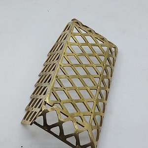 May include: A gold-colored metal mesh corner guard with a diamond pattern.
