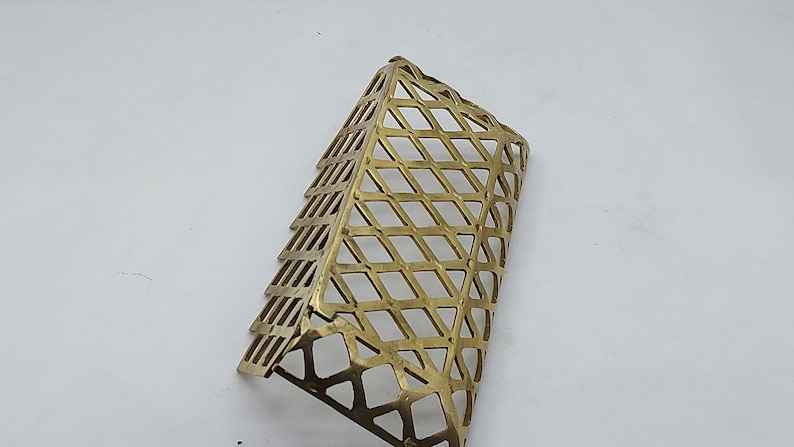May include: A gold-colored metal mesh corner guard with a diamond pattern.