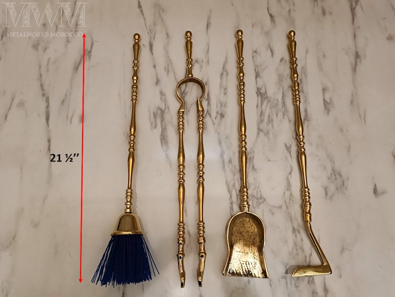 May include: Set of five gold-toned fireplace tools with decorative handles. The tools include a brush, tongs, shovel, poker, and a dustpan. The tools are 21 1/2 inches long.