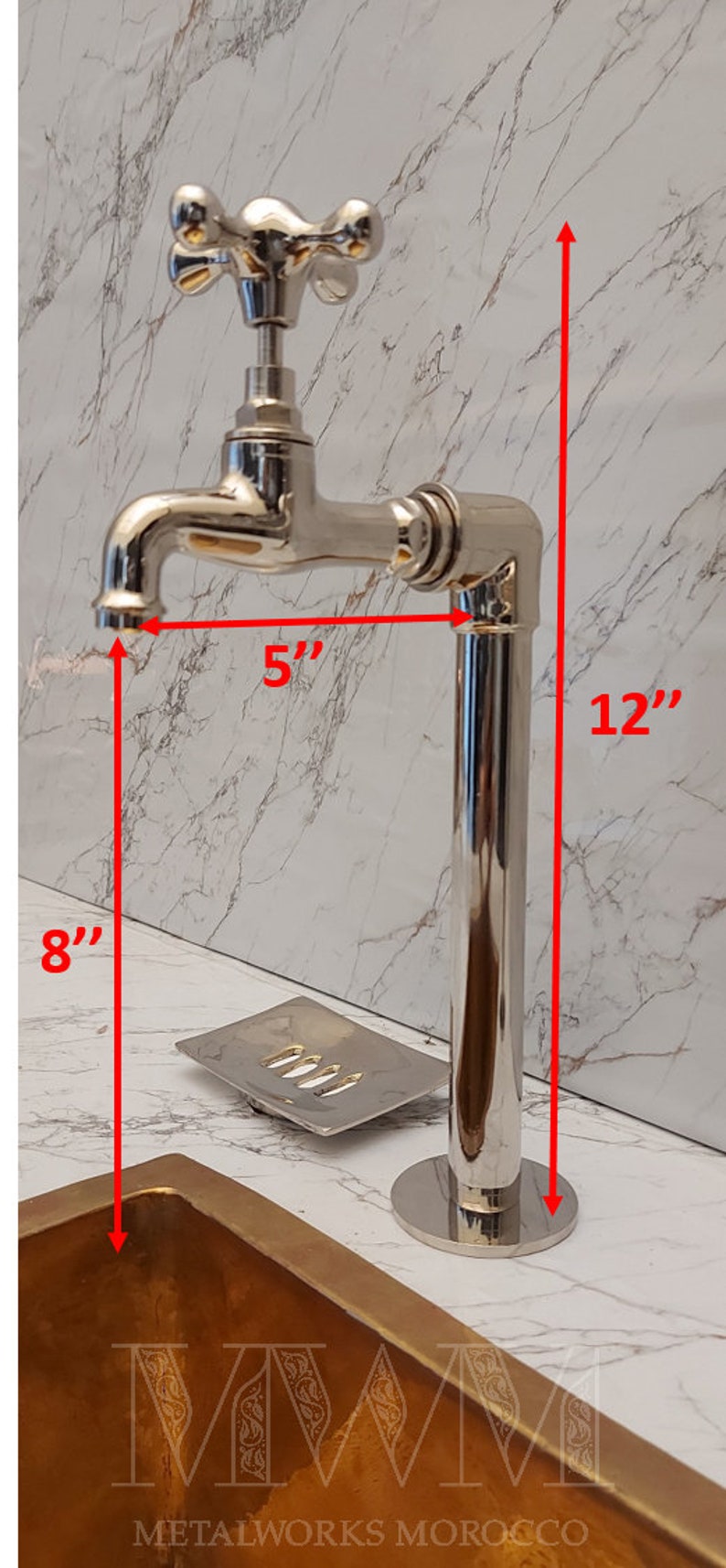 K&ouml;nnte beinhalten: Ein polierter Chrom-Wasserhahn mit einem kreuzf&ouml;rmigen Griff, montiert auf einem Chromrohr. Der Wasserhahn ist 5 Zoll hoch und das Rohr 12 Zoll hoch. Der Wasserhahn ist auf einer Arbeitsplatte mit einem Seifenspender und einem gro&szlig;en, goldfarbenen Waschbecken montiert.