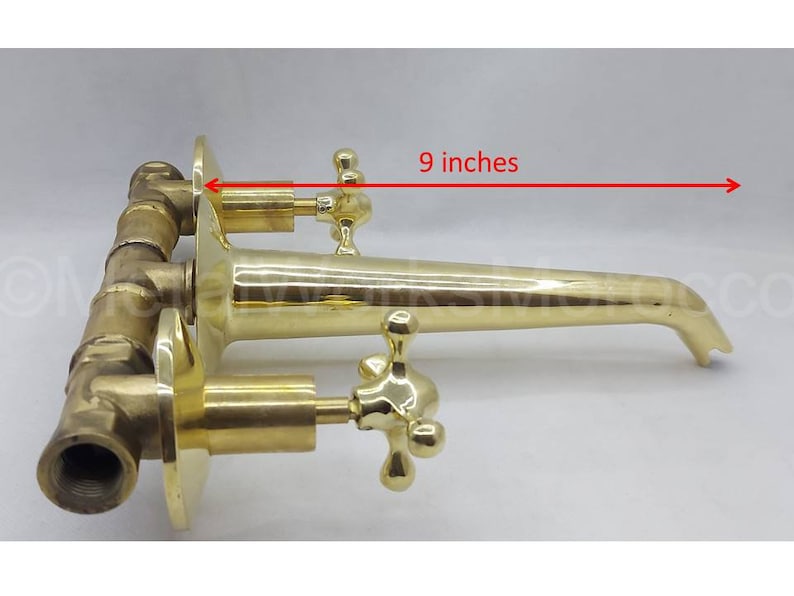 May include: Brass wall-mounted faucet with two cross-shaped handles and a 23 cm spout.
