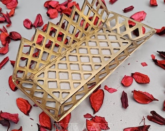 May include: A gold metal tray with a diamond pattern design. The tray is made of a thin metal and has a decorative edge.