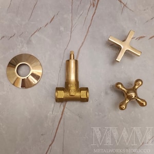 以下が含まれることがあります： 丸いベース、DN13 1/2の刻印のあるバルブ、十字形のハンドル、4本足のハンドルを含む、金色の浴室用金具のセットです。