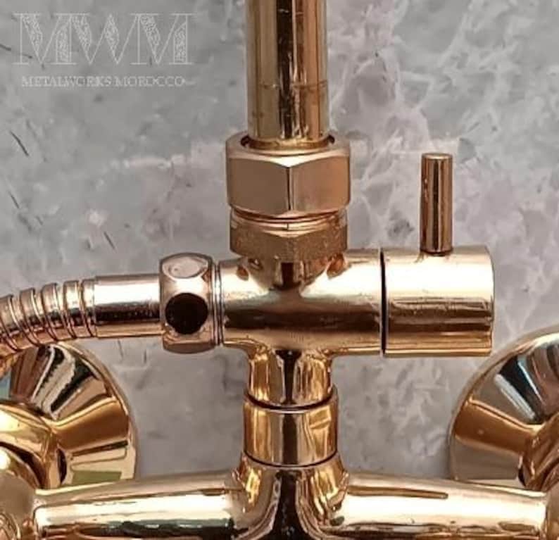 Puede incluir: Grifo de ducha dorado con una manija de palanca y una conexi&oacute;n de manguera. El grifo tiene un acabado pulido y est&aacute; hecho de metal.