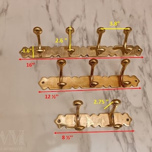 May include: Three brass coat racks of varying sizes. The largest is 16 inches wide with three hooks, the medium is 12.5 inches wide with three hooks, and the smallest is 8.5 inches wide with two hooks. Each hook is approximately 2.6 inches tall.