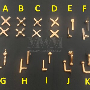 May include: Assortment of gold-toned metal cabinet hardware, including drawer pulls, knobs, and handles. The hardware is labeled with letters A through K.