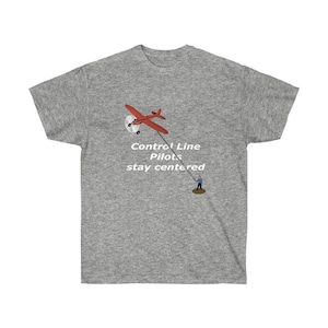 May include: A heather grey t-shirt with a red airplane and a person holding a string attached to the plane. The text on the shirt reads "Control Line Pilots stay centered".