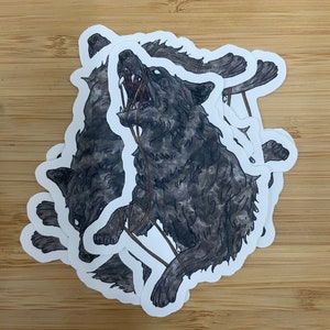 May include: A black and white sticker of a wolf howling with its mouth open, surrounded by a brown rope. The wolf is depicted in a realistic style with fur details.