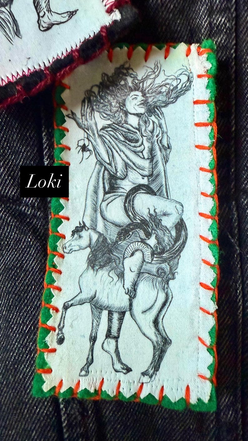 May include: A rectangular patch with a black and white illustration of a figure riding a horse-like creature, with a snake wrapped around it. The patch has green and orange stitching and the word "Loki".
