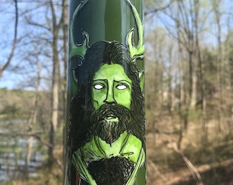 Op de afbeelding: Groene kaars met een handgeschilderd beeld van een man met geweien, een baard en een groen-zwart gepatroneerd shirt.