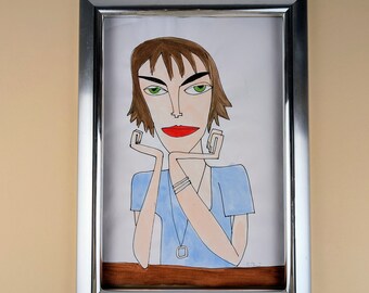 Può includere: Un disegno incorniciato di una donna con capelli castani, occhi verdi e labbra rosse. Indossa una camicia blu chiaro e una collana d'argento con un ciondolo.