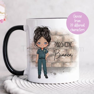 Può includere: Una tazza in ceramica bianca con un manico nero. La tazza presenta un'illustrazione di cartone animato di una donna paramedico con capelli castani e occhi azzurri. Il testo "PARAMEDIC Bianca" è stampato sulla tazza.