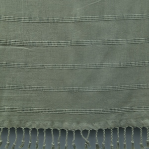 May include: A green striped cotton towel with fringe on the bottom edge.