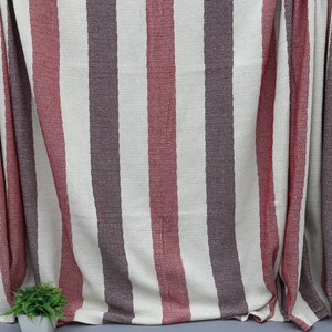 May include: A striped throw blanket with red, white, and brown stripes. The blanket has a fringe border and is made of a soft, woven fabric.