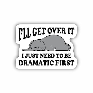 May include: A white sticker with a black border and text that reads "I'll get over it, I just need to be dramatic first." A gray cartoon elephant is lying down between the text.