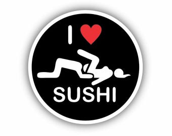 Pode incluir: Um autocolante redondo com fundo preto e borda branca. Apresenta as palavras "I LOVE SUSHI", um coração vermelho e um gráfico estilizado de duas figuras. O design é simples e arrojado.