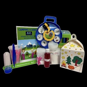 Puede incluir: Kit de ciencia de campamento con una lupa azul, un libro titulado "Camping Science: Explore the Outdoors and the Science Inside", una caja con una fogata y árboles, y varios suministros científicos.