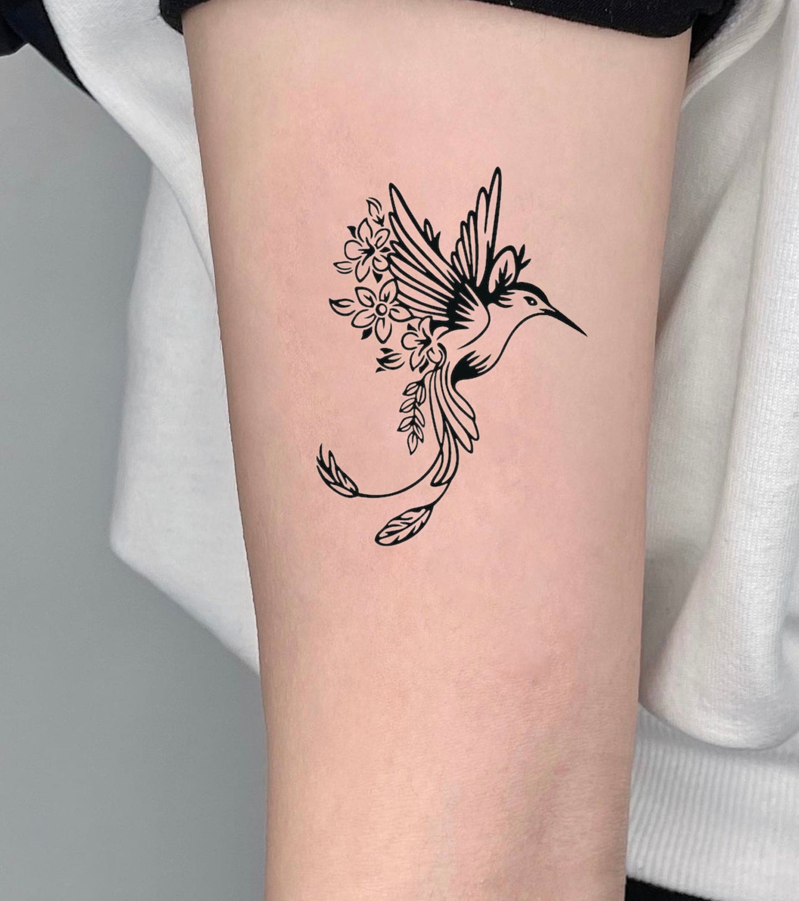 Micro-realistic hummingbird tattoo on the ankle.