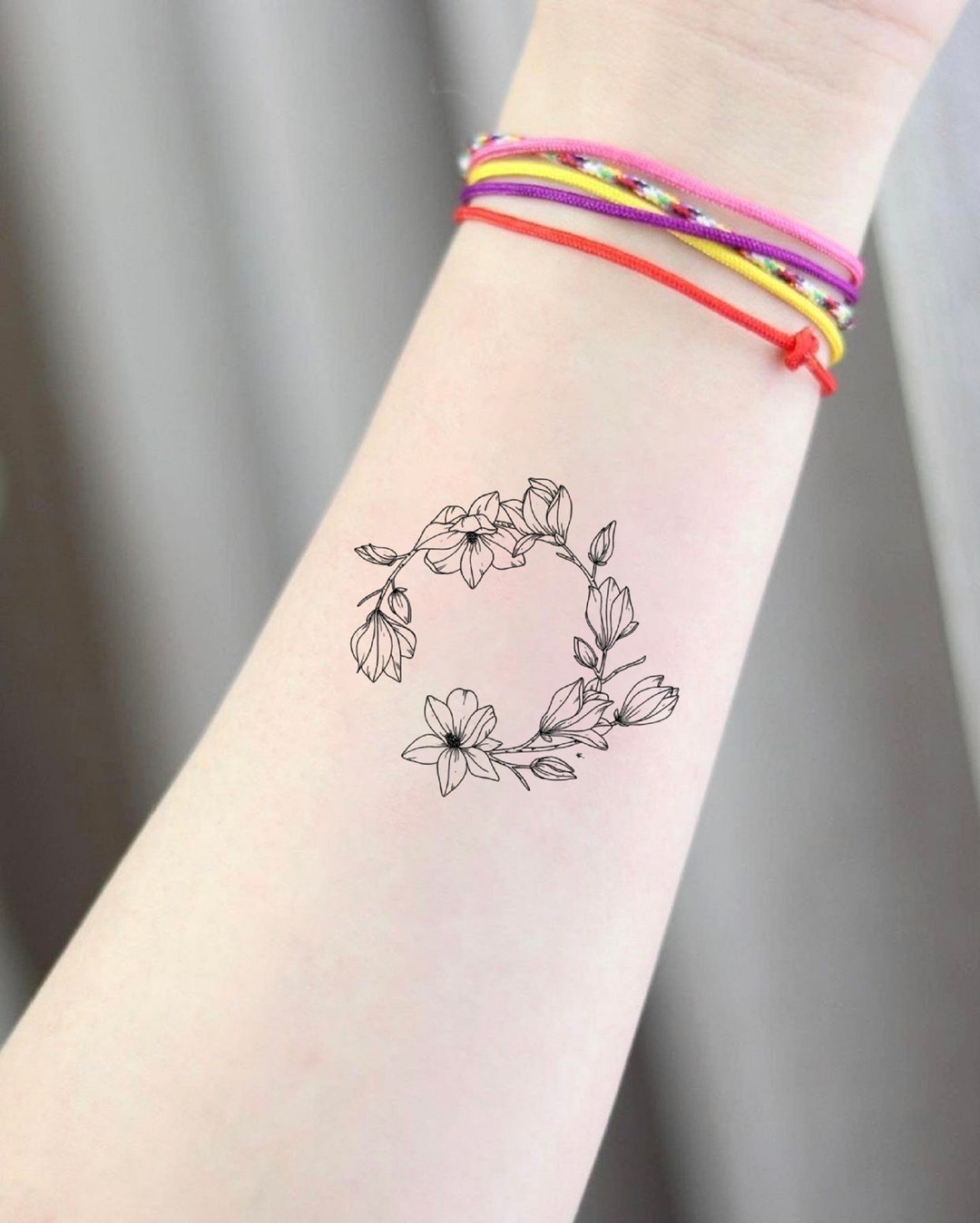Flower bracelet tattoo on the right wrist.