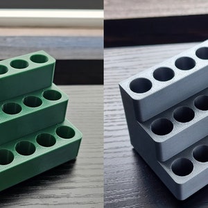 K&ouml;nnte beinhalten: Ein dreistufiger, 3D-gedruckter Organizer mit 18 runden L&ouml;chern, einer in Gr&uuml;n und einer in Grau. Der Organizer ist so konzipiert, dass er kleine Gegenst&auml;nde wie Stifte, Bleistifte oder Pinsel aufnehmen kann.