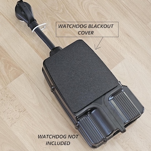 May include: A black Watchdog Blackout Cover with a textured surface and a black handle. The text "WATCHDOG BLACKOUT COVER" is in a white box. The text "WATCHDOG NOT INCLUDED" is also visible.