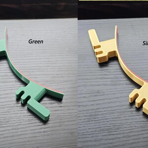 May include: Two plastic hair clips, one green and one gold, with a red stripe on the inside of the curve. The clips are shaped like a hand with three fingers.
