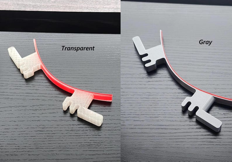 May include: Two 3D printed plastic parts, one transparent and one gray, with a red line running along the edge of each. The text "Transparent" is above the transparent part and the text "Gray" is above the gray part.