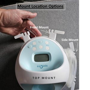May include: A white and blue Spectra electric breast pump with a digital display and multiple buttons. The pump has three mounting options: front, side, and top.