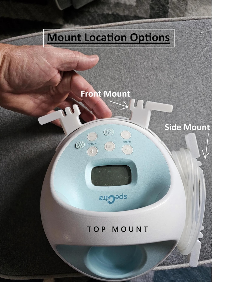 May include: A white and blue Spectra electric breast pump with a digital display and multiple buttons. The pump has three mounting options: front, side, and top.
