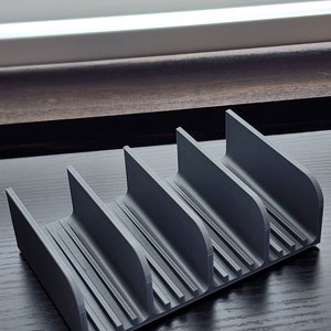 May include: A gray plastic organizer with four compartments. The organizer has a ribbed texture and is designed to hold small items.