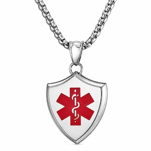 May include: A silver pendant necklace. The pendant is shield-shaped, with a white background and a red Star of Life symbol. The chain is a box chain style. The medical symbol is a symbol of emergency medical services.